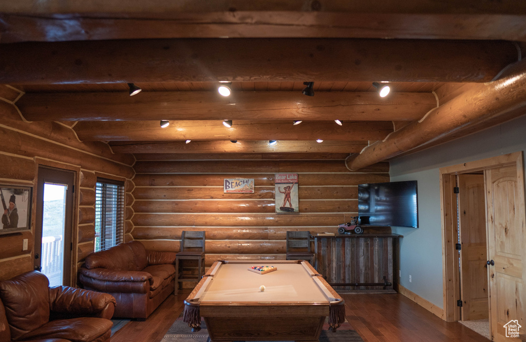 Interior space with dark wood-type flooring, beam ceiling, log walls, and pool table