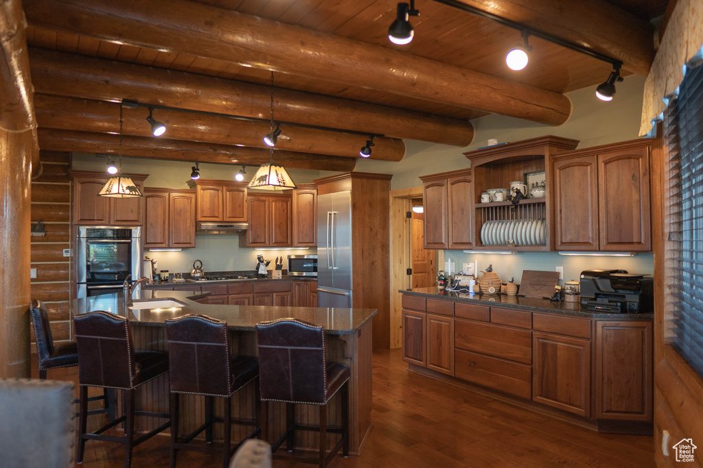 Kitchen featuring a kitchen bar, a kitchen island, decorative light fixtures, and beam ceiling