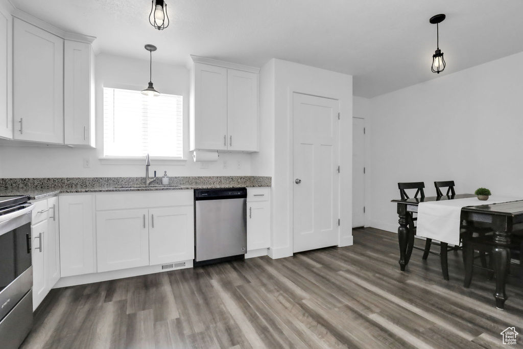 Kitchen featuring dark hardwood / wood-style flooring, sink, dishwasher, and hanging light fixtures