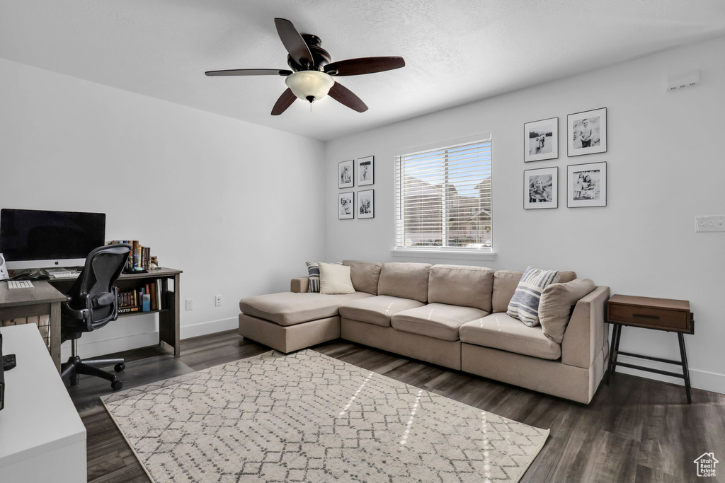 Living room featuring dark hardwood / wood-style flooring and ceiling fan