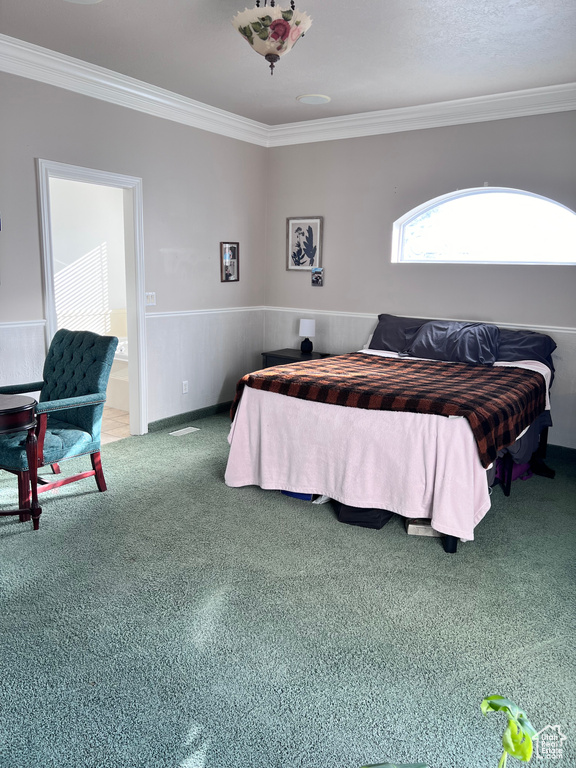 Carpeted bedroom with crown molding and ensuite bath