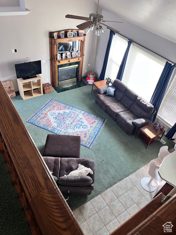 Carpeted living room featuring vaulted ceiling and ceiling fan