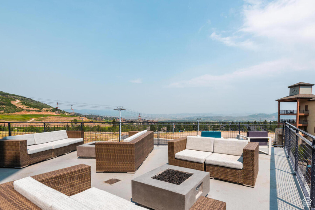View of terrace with a mountain view, a balcony, and an outdoor living space with a fire pit