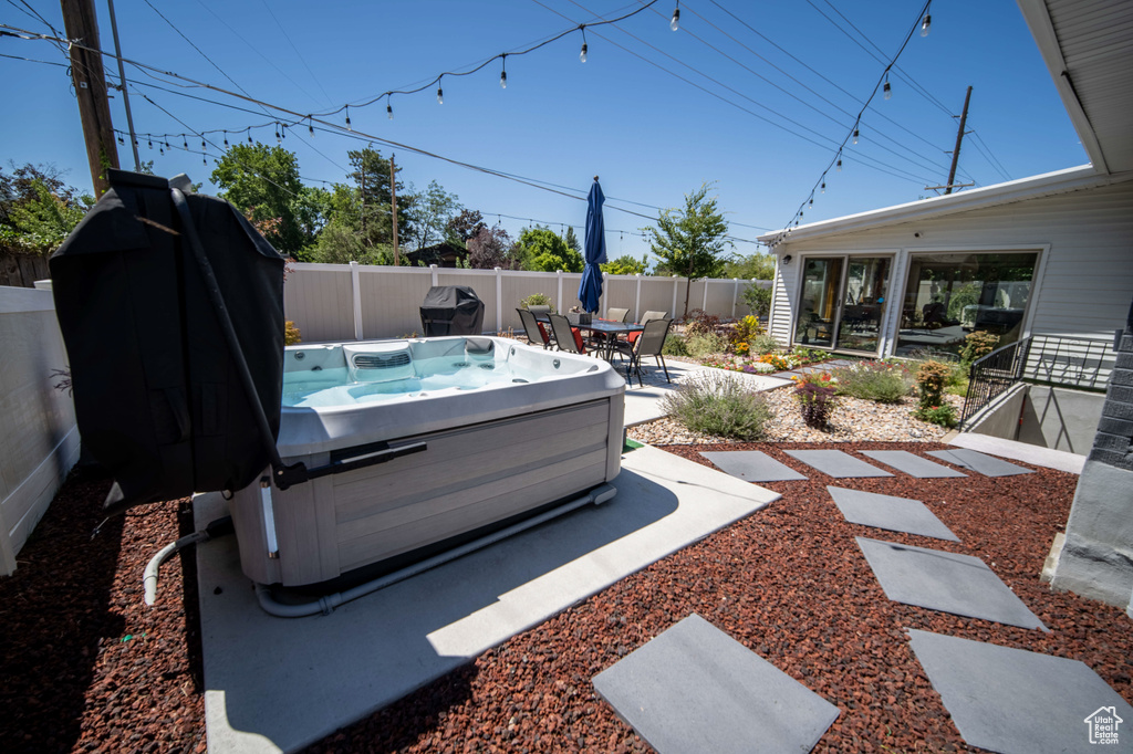View of yard featuring a hot tub and a patio area