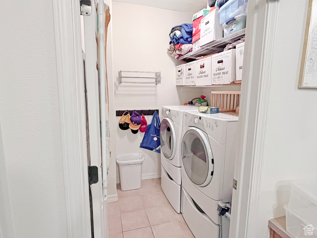 Washroom featuring light tile floors and separate washer and dryer
