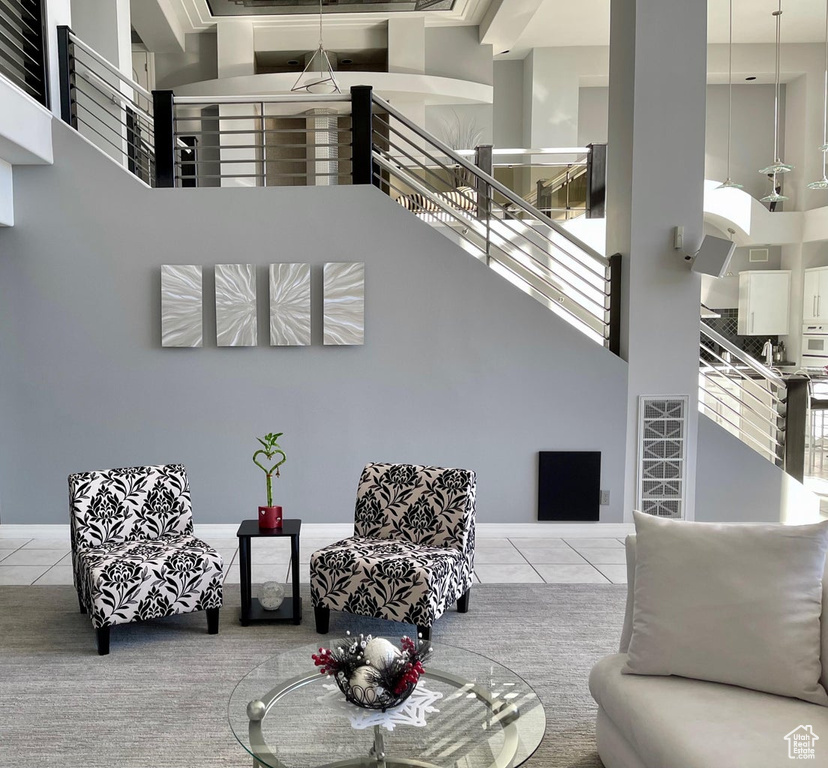 Tiled living room featuring a wealth of natural light and a high ceiling