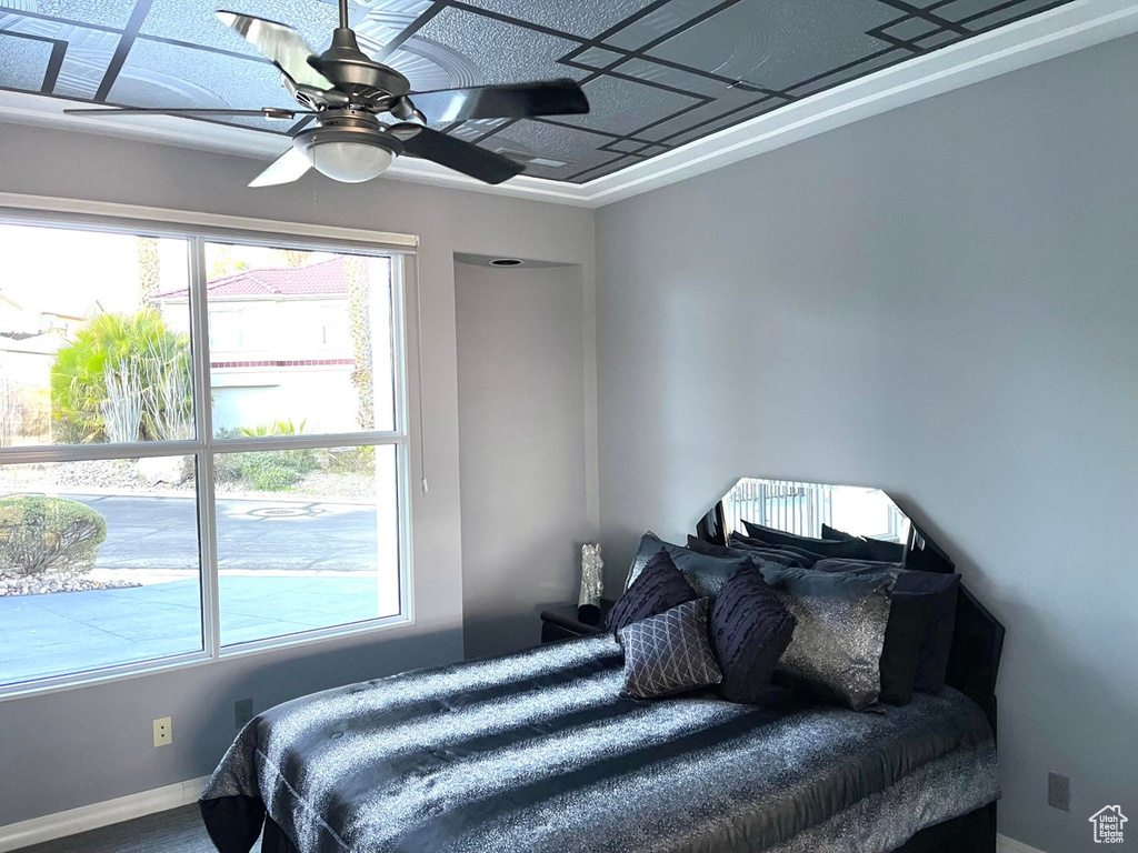 Carpeted bedroom featuring ceiling fan