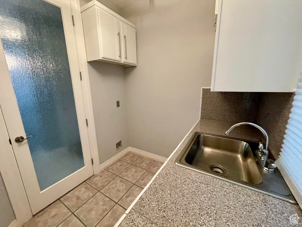 Laundry room with light tile floors and sink