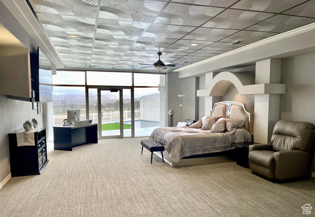 Carpeted bedroom featuring expansive windows and access to exterior