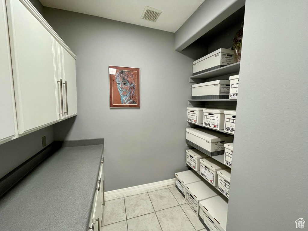 Clothes washing area featuring light tile flooring