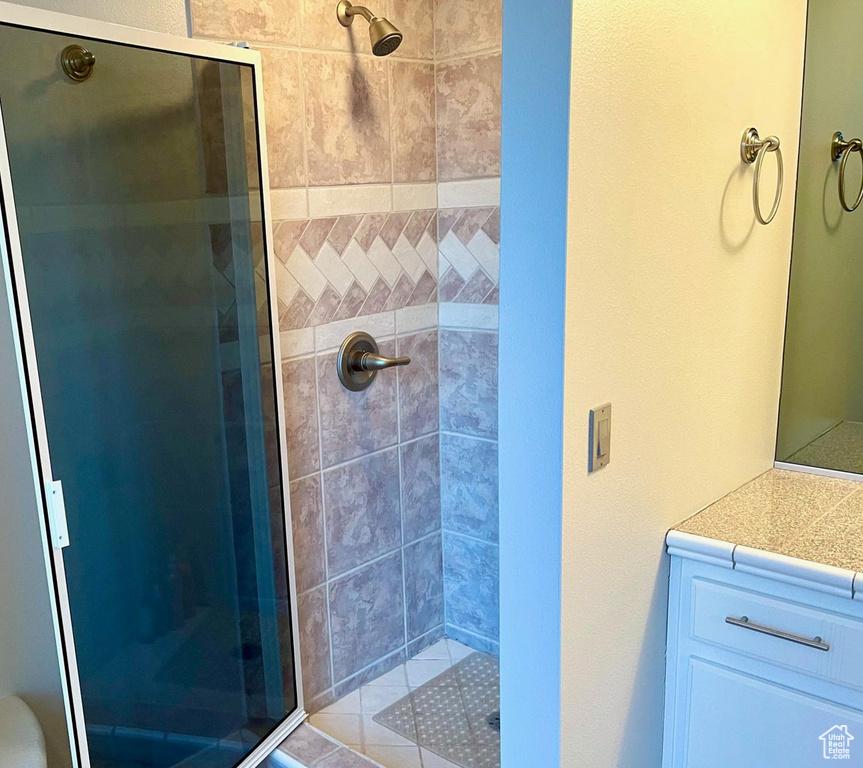 Bathroom featuring vanity and a shower with door