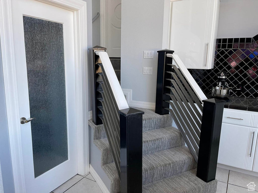 Staircase featuring light tile floors