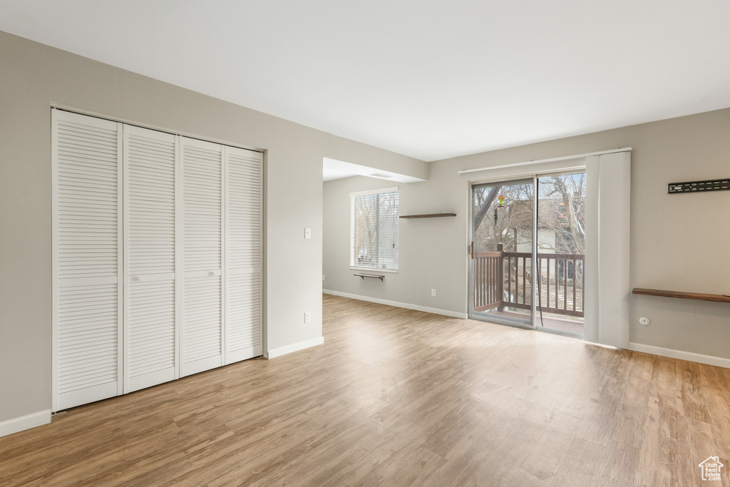 Unfurnished bedroom with light hardwood / wood-style flooring, a closet, and access to outside