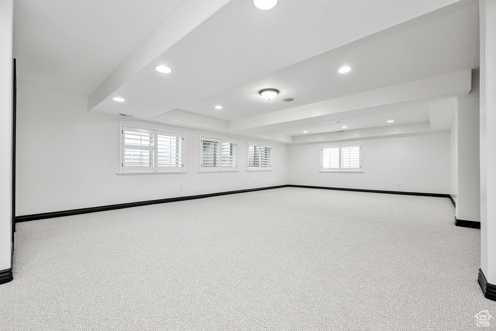 Carpeted spare room with a raised ceiling