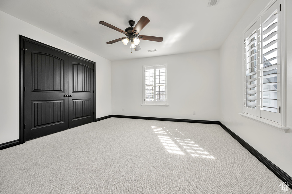 Unfurnished bedroom featuring a closet, carpet flooring, and ceiling fan