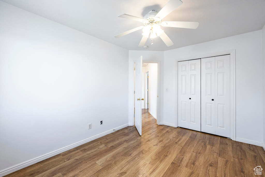 Unfurnished bedroom featuring dark hardwood / wood-style floors, a closet, and ceiling fan