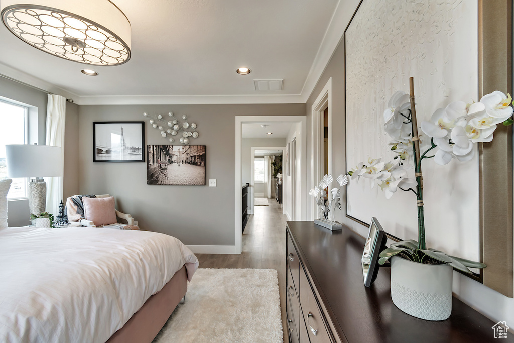Bedroom featuring ornamental molding and light hardwood / wood-style floors