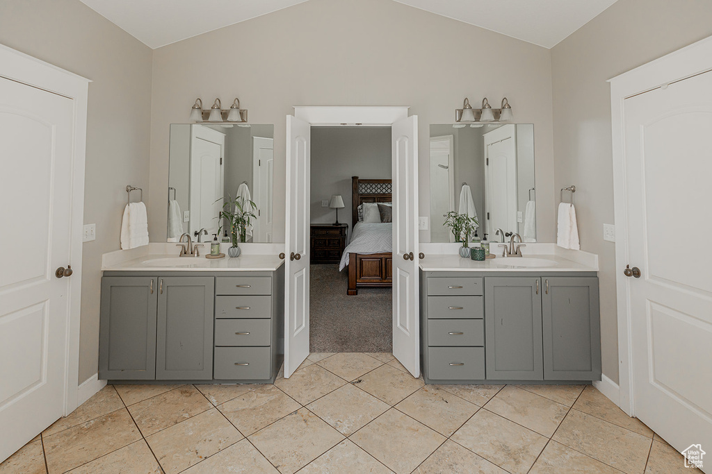 Bathroom with vaulted ceiling, tile floors, and vanity