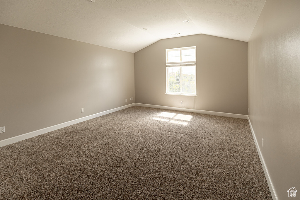 Interior space with carpet floors and vaulted ceiling