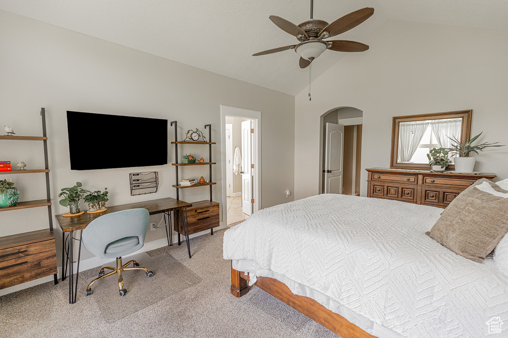 Bedroom featuring high vaulted ceiling, light carpet, ensuite bath, and ceiling fan