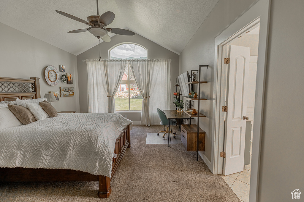 Bedroom featuring ceiling fan, light colored carpet, lofted ceiling, and a textured ceiling