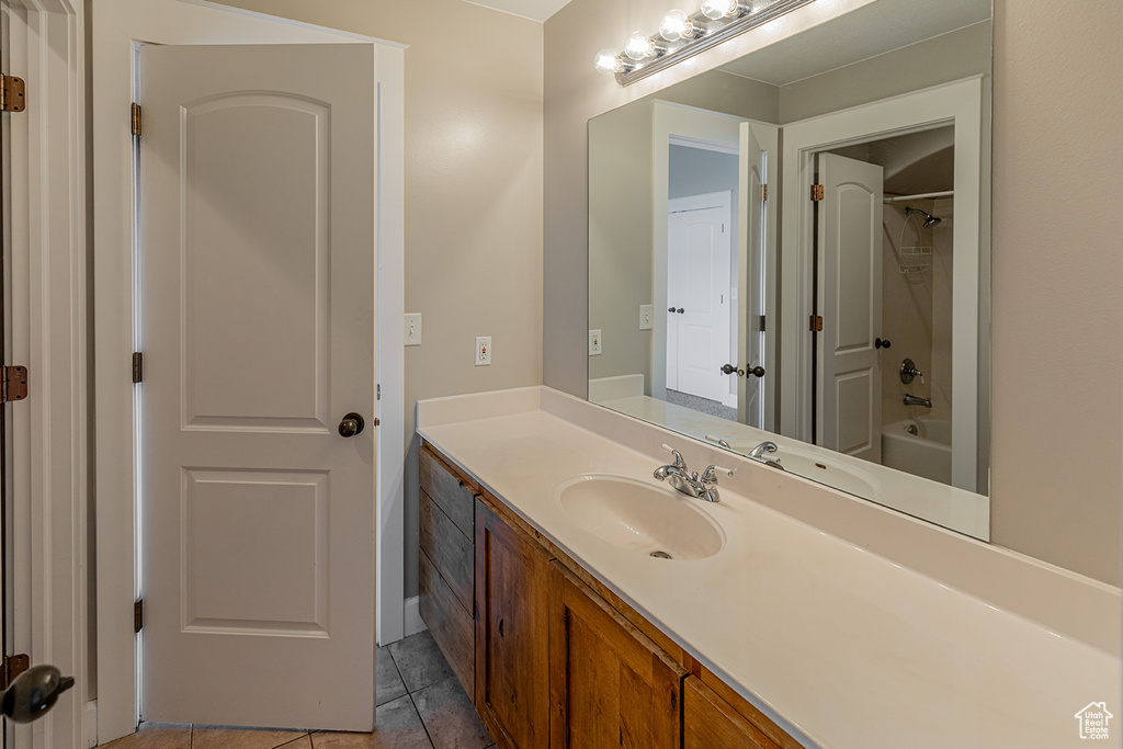 Bathroom featuring large vanity, shower / bathtub combination, and tile floors