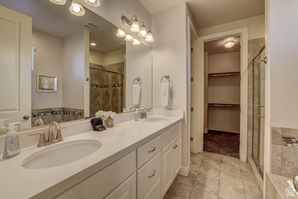 Bathroom featuring plus walk in shower, tile floors, and double sink vanity