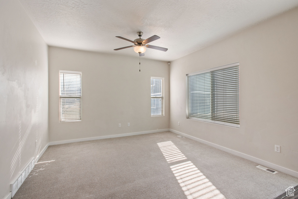 Spare room with light colored carpet and ceiling fan