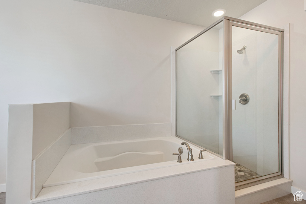 Bathroom with shower with separate bathtub and a textured ceiling