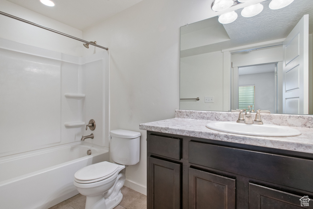 Full bathroom with tub / shower combination, vanity with extensive cabinet space, a textured ceiling, toilet, and tile flooring