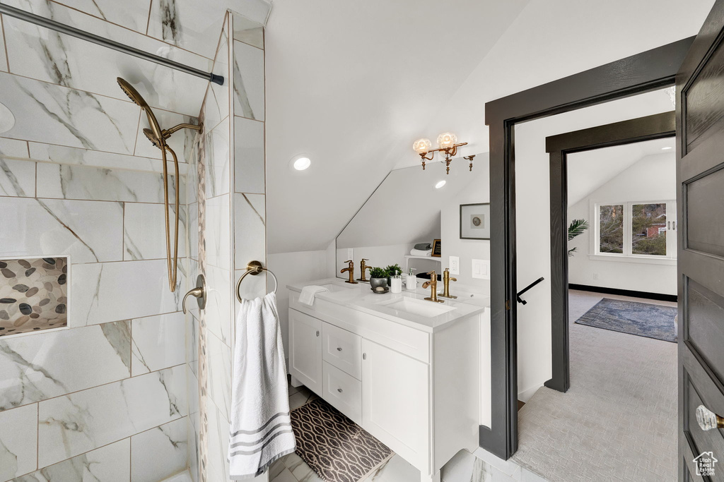 Bathroom with vanity, vaulted ceiling, and walk in shower