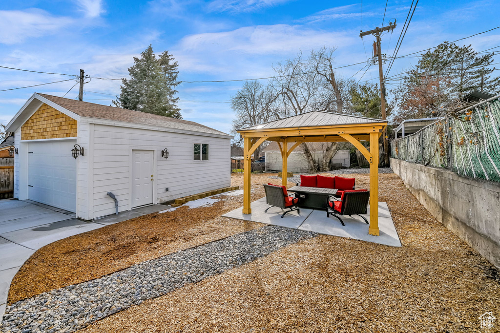 View of yard with a garage, an outdoor living space, and a gazebo