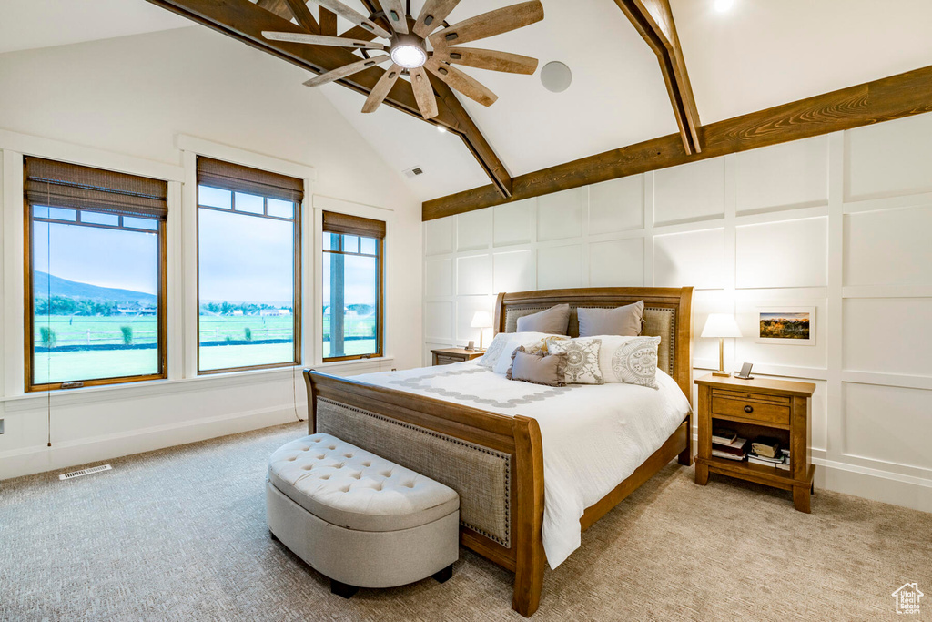 Bedroom with vaulted ceiling, light carpet, multiple windows, and ceiling fan