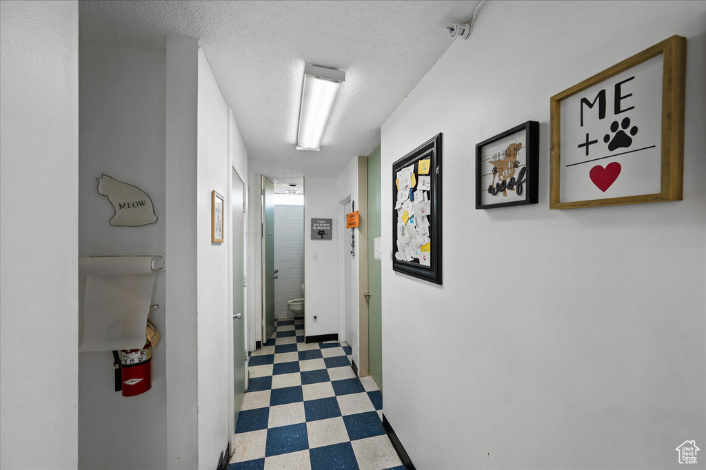 Hallway featuring tile flooring and a textured ceiling