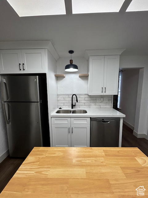 Kitchen with dark hardwood / wood-style flooring, stainless steel refrigerator, tasteful backsplash, and dishwasher