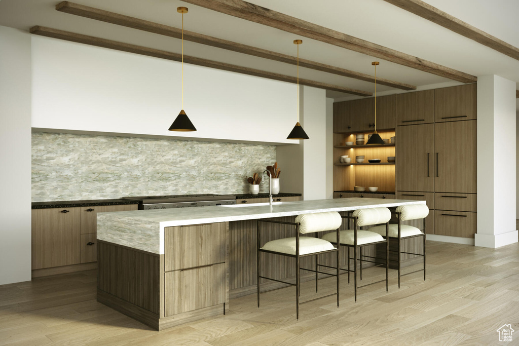 Interior space featuring a kitchen bar, light hardwood / wood-style floors, sink, and decorative light fixtures