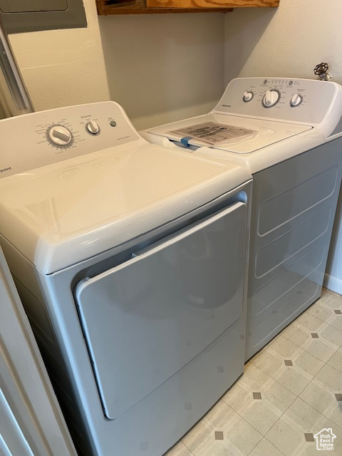 Laundry room featuring light tile floors and washing machine and clothes dryer