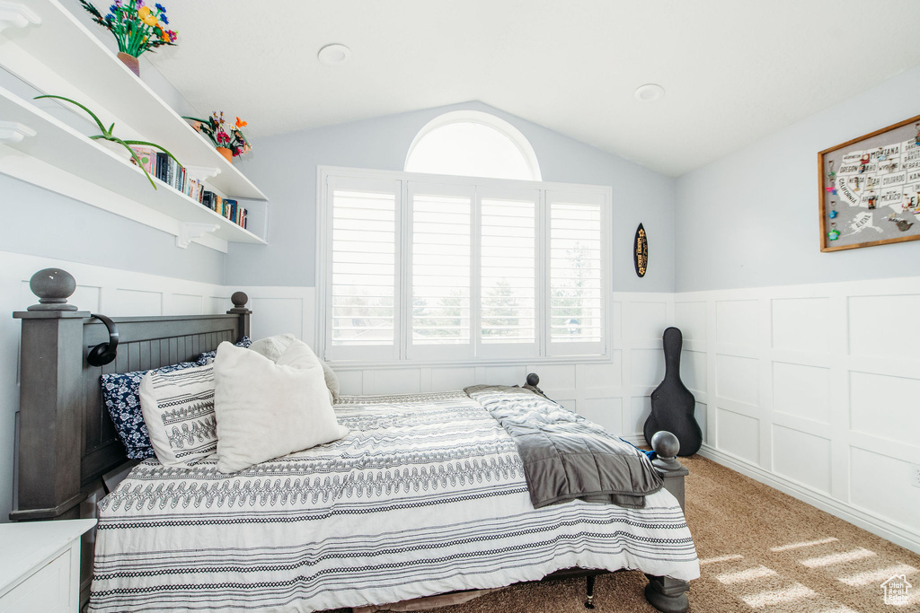 Bedroom with vaulted ceiling and light colored carpet