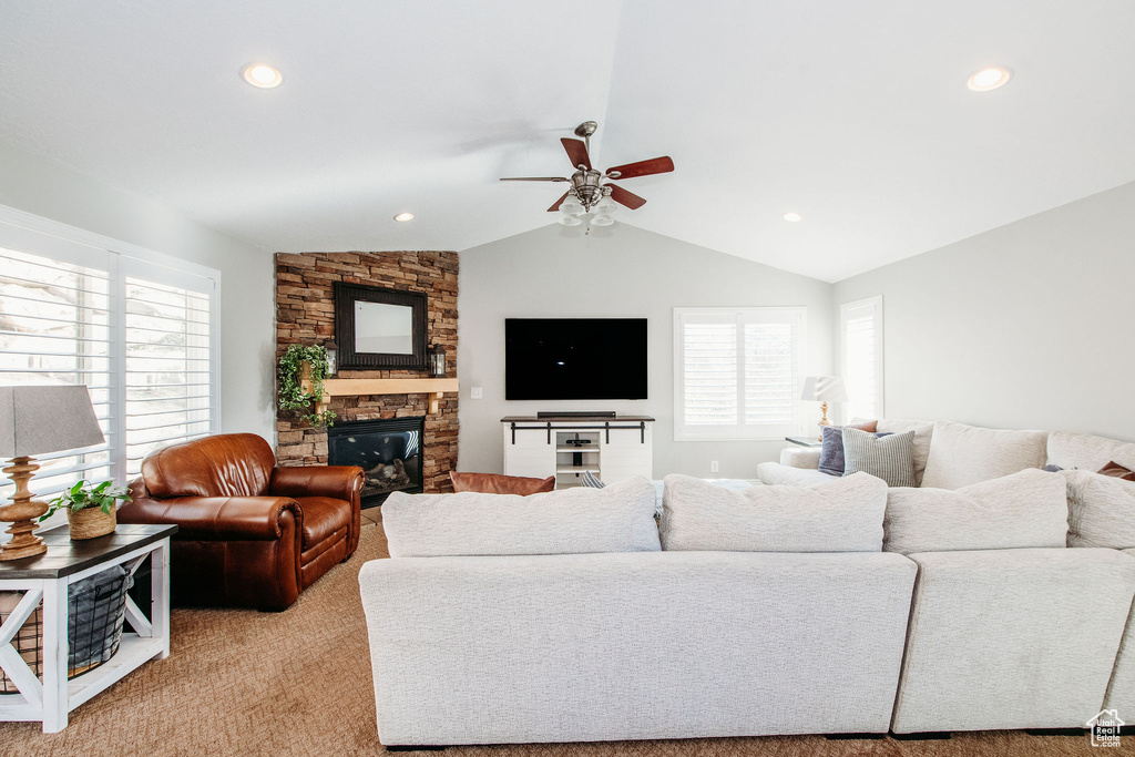 Living room with vaulted ceiling, a fireplace, a wealth of natural light, and ceiling fan