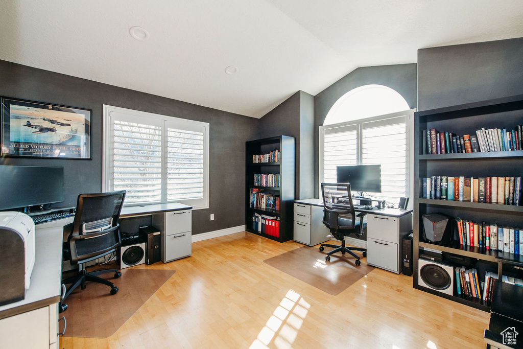 Home office featuring vaulted ceiling and light hardwood / wood-style floors
