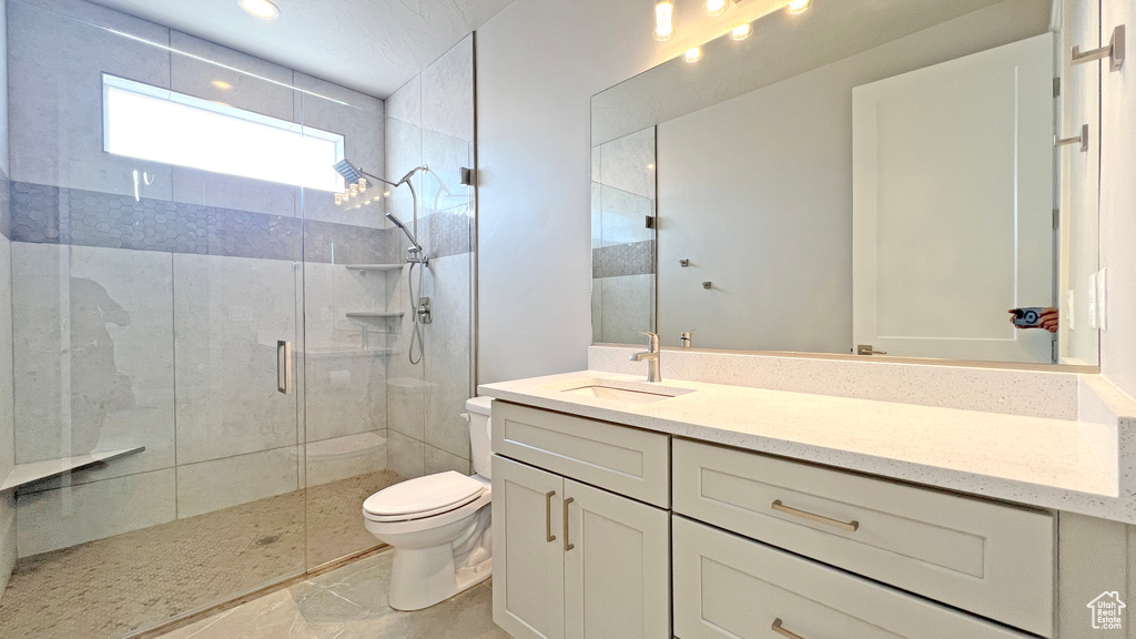 Bathroom with toilet, a shower with door, tile flooring, and large vanity