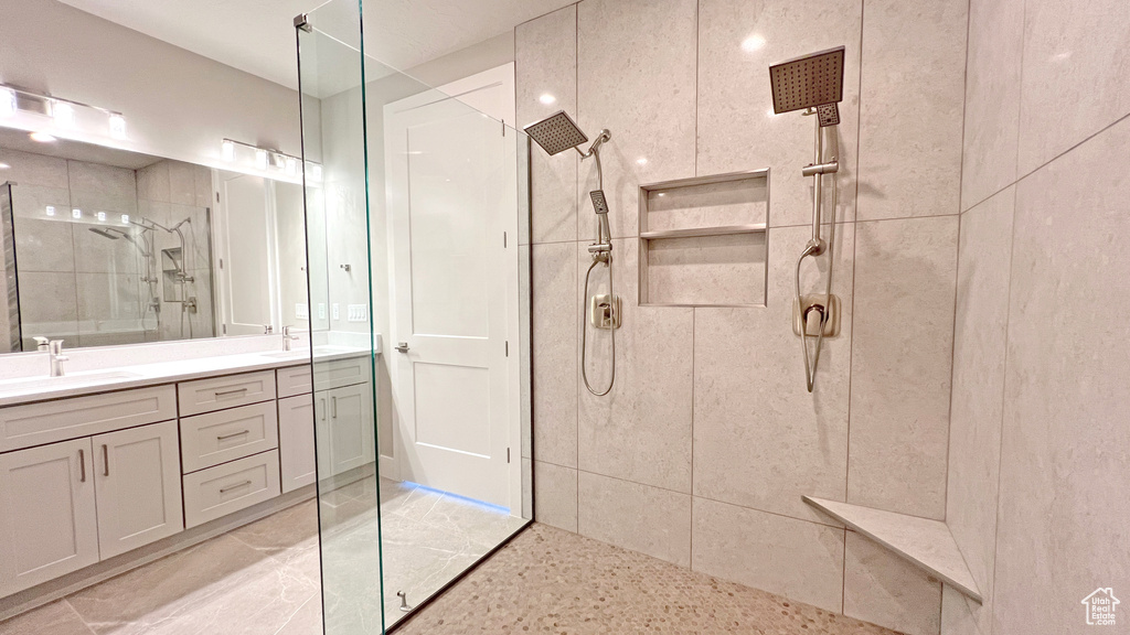 Bathroom with tile flooring, large vanity, and walk in shower