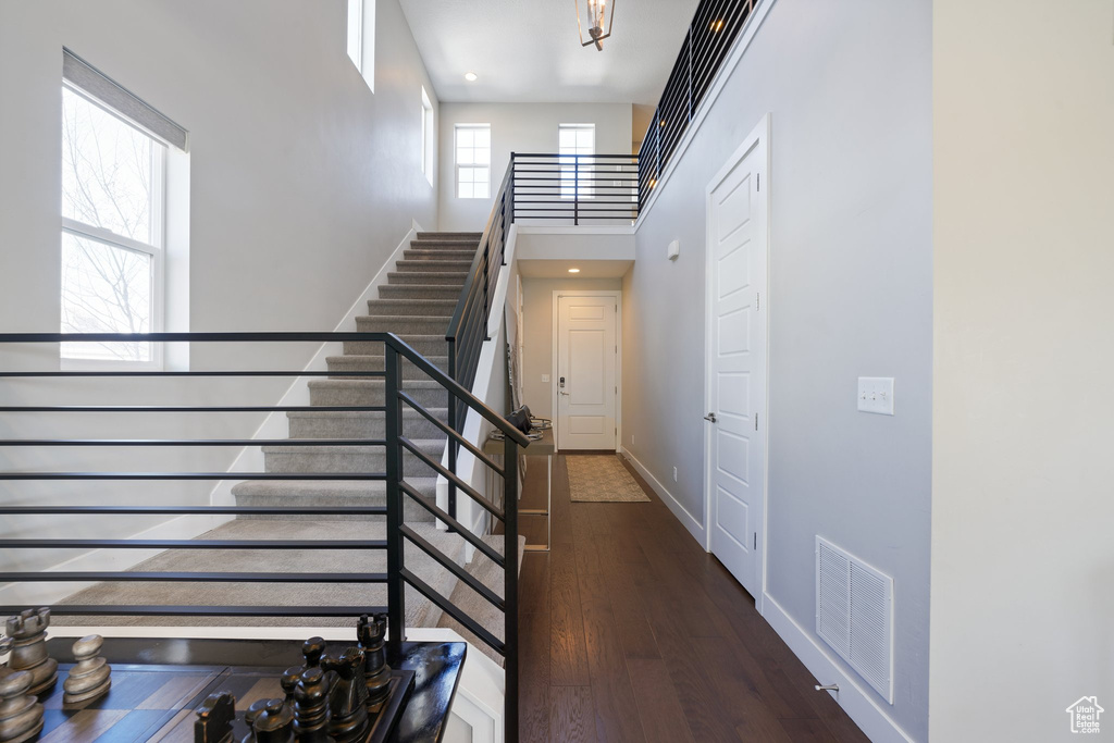 Stairway featuring a high ceiling and dark wood-type flooring