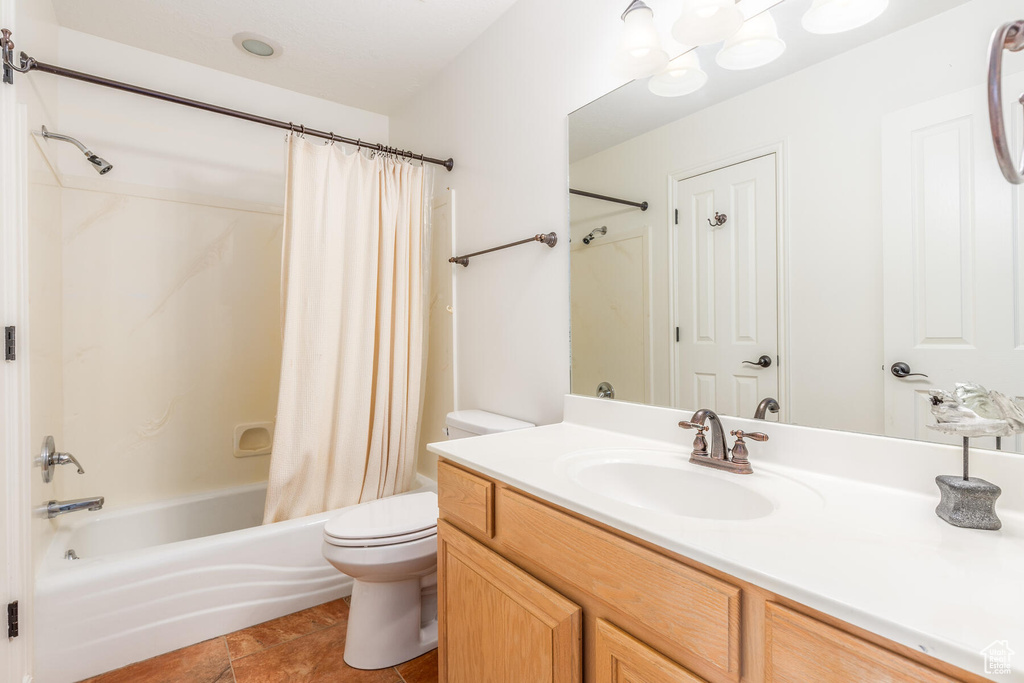 Full bathroom with shower / bathtub combination with curtain, tile floors, large vanity, and toilet