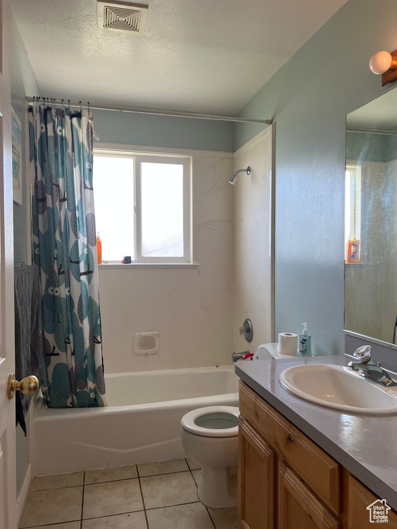 Full bathroom with shower / bathtub combination with curtain, tile floors, toilet, and vanity