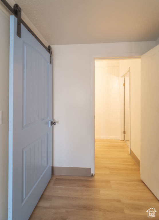 Corridor featuring light hardwood / wood-style flooring and a barn door