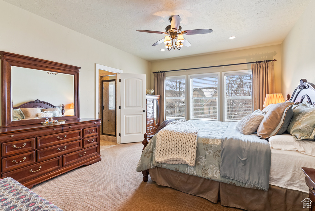 Bedroom featuring light colored carpet, a textured ceiling, and ceiling fan