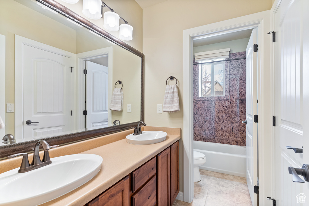 Full bathroom with shower / washtub combination, toilet, double sink vanity, and tile floors