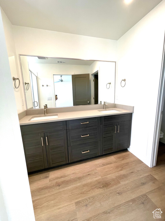 Bathroom featuring double sink vanity and wood-type flooring