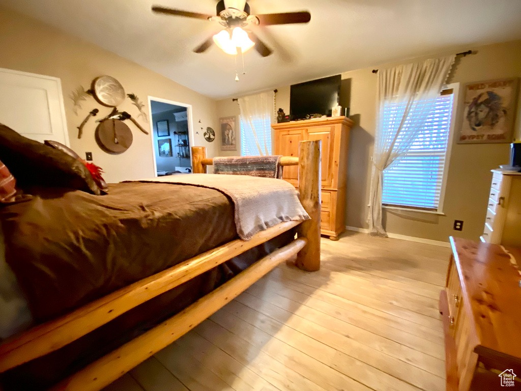 Bedroom featuring light wood-type flooring, ceiling fan, and vaulted ceiling